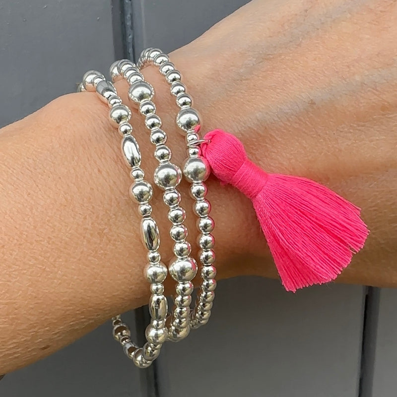 Modelled sterling silver and neon tassel stacking bracelets